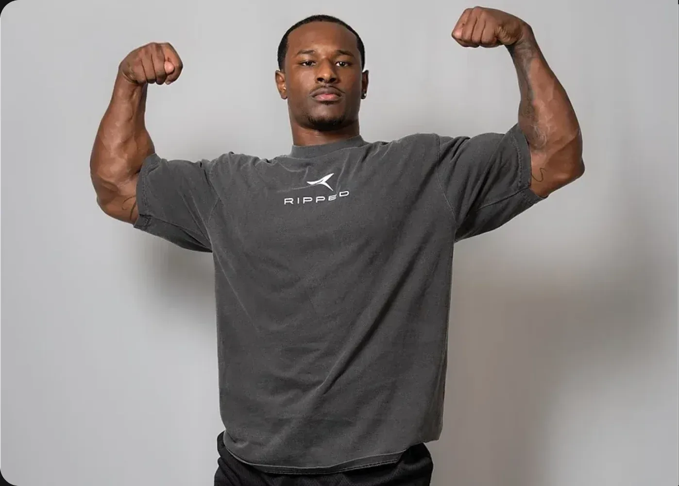 An athlete flexing in a RIPPED tee